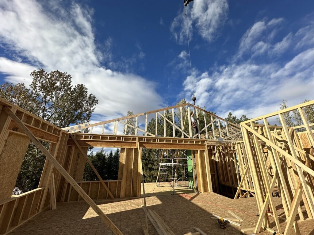 Photograph of the upper floor framing in progress at a construction project undertaken by Fort Collins-based design-build firm. The image captures the skilled craftsmanship and attention to detail as the framework of the upper level takes shape. Construction workers can be seen diligently working on the structure, showcasing the firm's commitment to quality and local expertise.